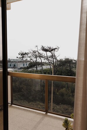 A balcony with a view of a building and trees.