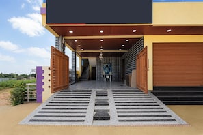 A modern building with a covered entrance, a staircase leading to the interior, and a view of the sky. - Hotel O Shadnagar (Balanagar)