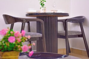 Uma área de refeições com uma mesa redonda e duas cadeiras.