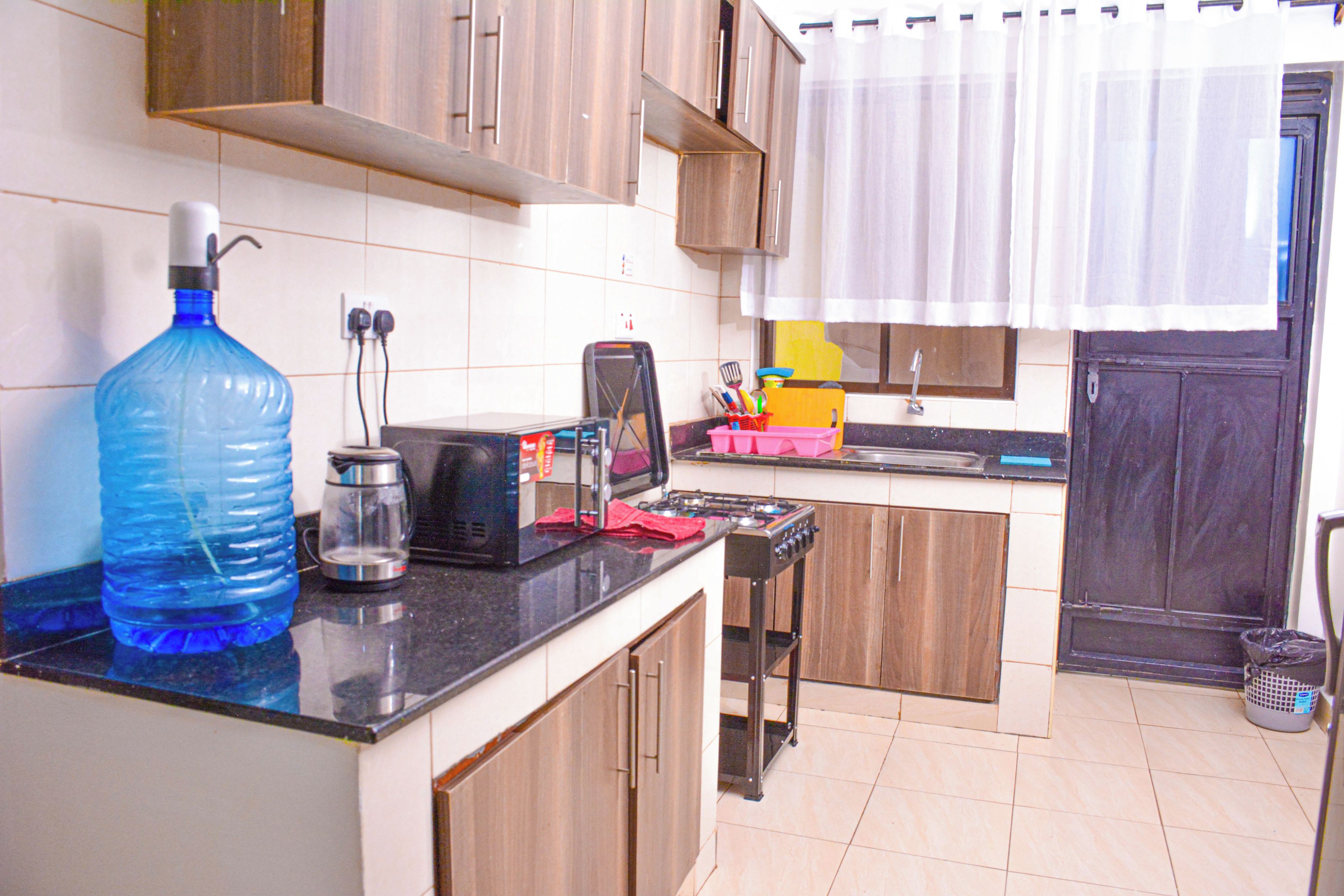 A kitchen with a water dispenser, a toaster, and a stove.