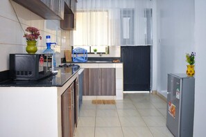 Cozinha compacta com micro-ondas, pia e armários.