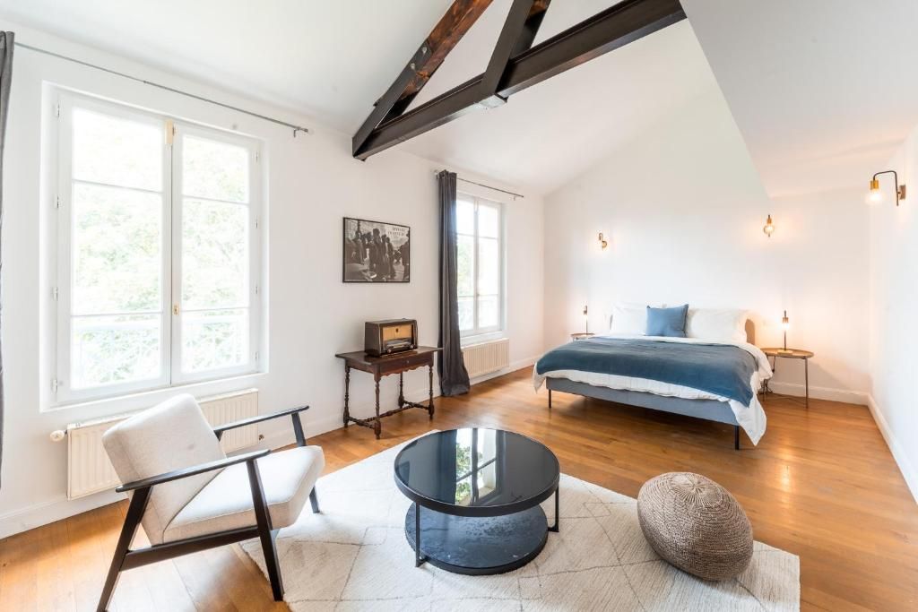 A bedroom with a bed, bedside table, and a window.