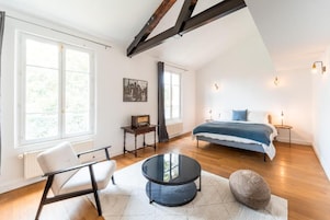 Un dormitorio con cama, mesita de noche y ventana.
