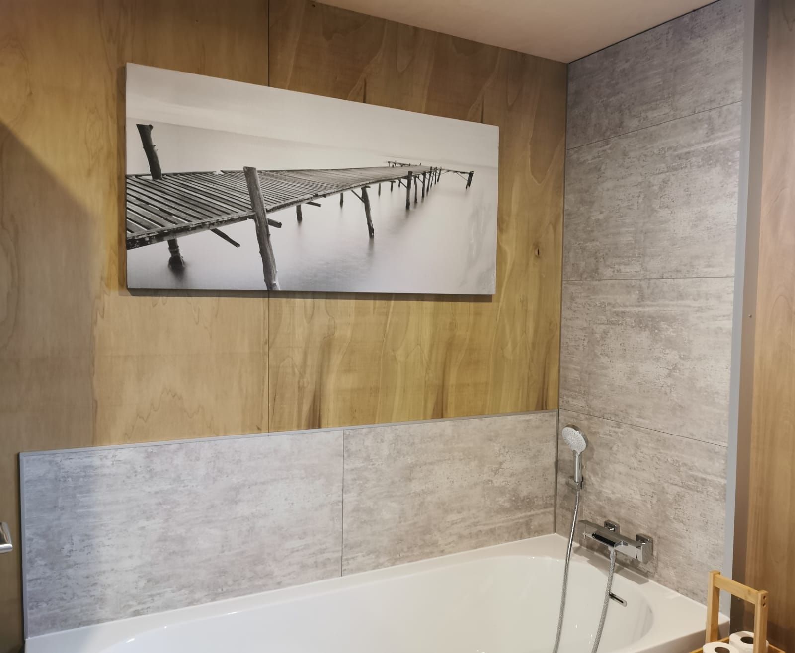 Une salle de bain avec un mur en bois, une grande baignoire et une douche.