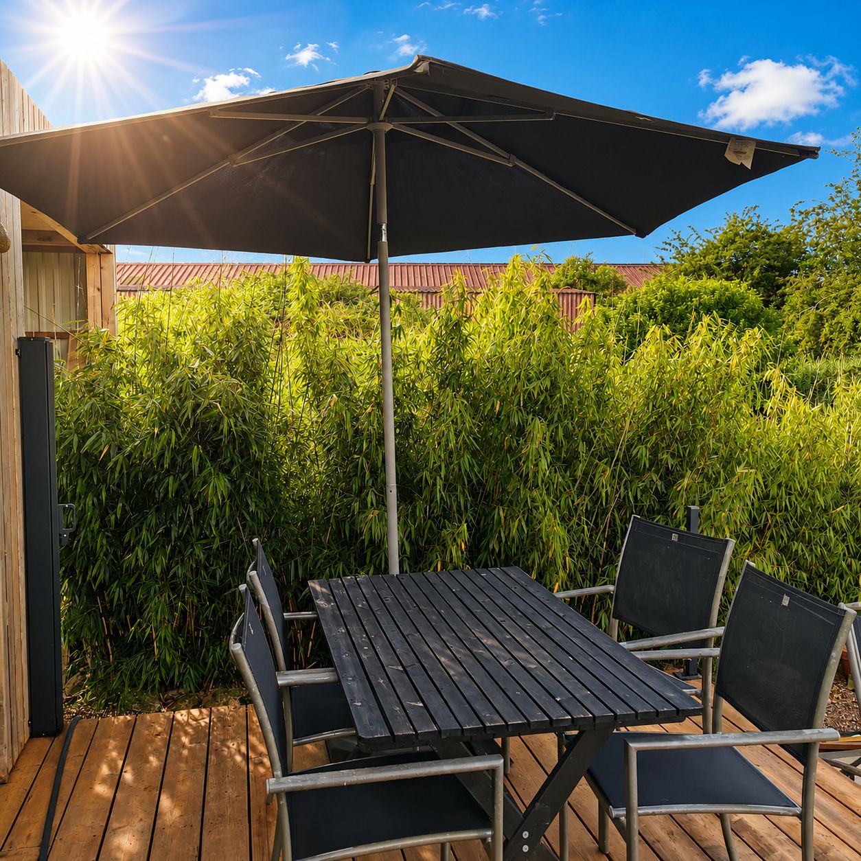 Une terrasse extérieure avec une table et des chaises, un grand parasol et une plateforme en bois.
