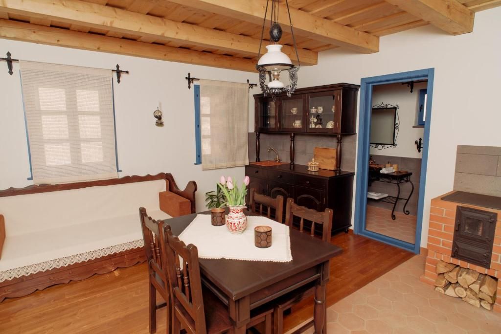 Un comedor con mesa de madera, sillas, una lámpara de araña y una chimenea.