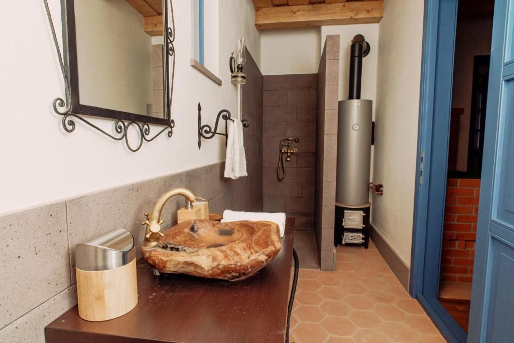 Un baño con tocador de madera, un espejo grande, toallero, zona de ducha y sauna.