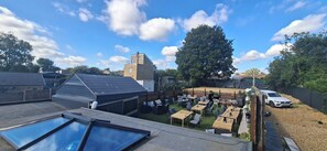 A rooftop terrace with a swimming pool, outdoor seating area, and a view of the surrounding neighborhood. - Deluxe one-bed apartment in Yaxley near A1 (Yaxley)