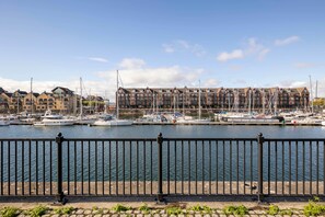 A marina with boats docked, a waterfront promenade, and residential buildings in the background. - Spacious 4-Bed Marina Home, Parking, Near City (Liverpool)