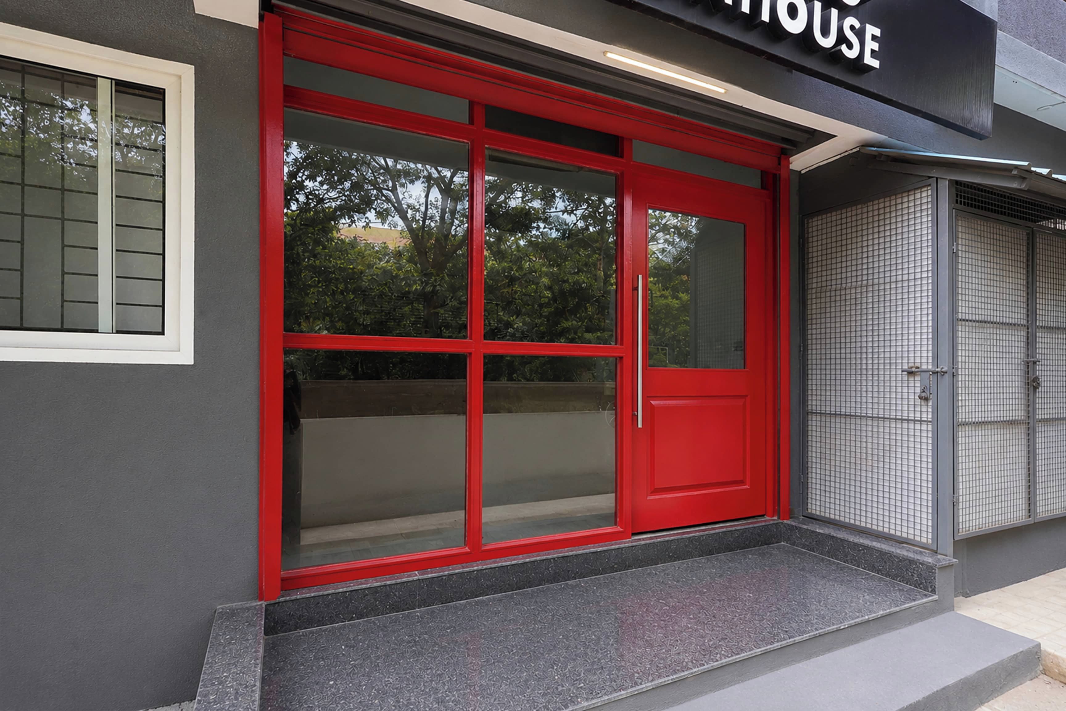 A building with a red door and a sign above it.