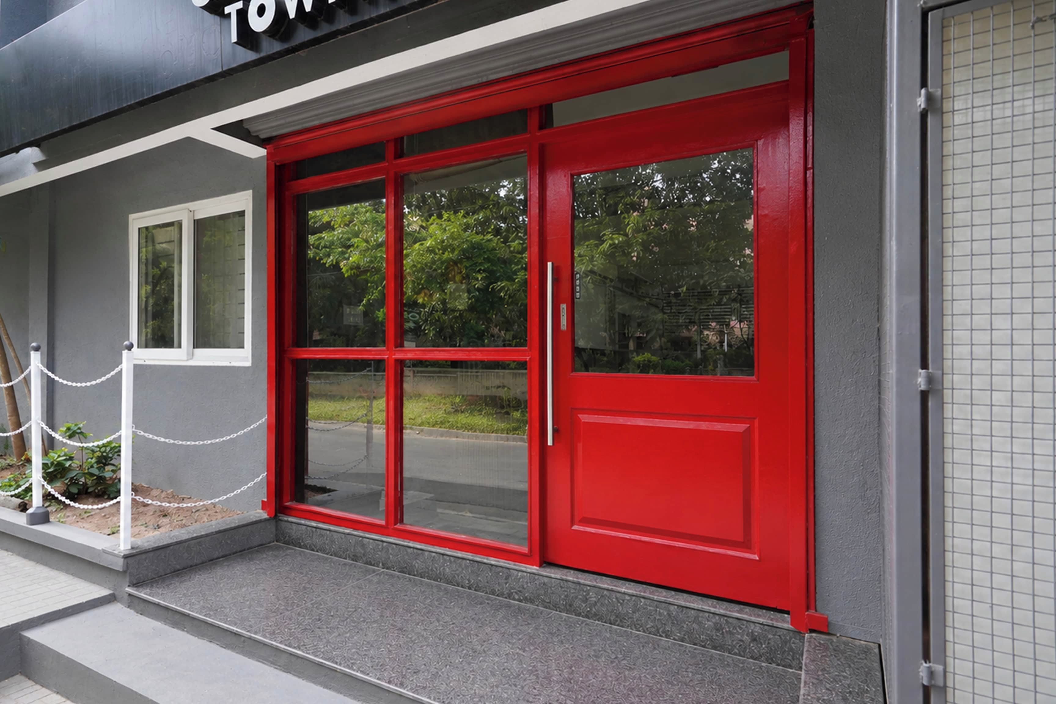 A building entrance with a red door and a chain barrier.