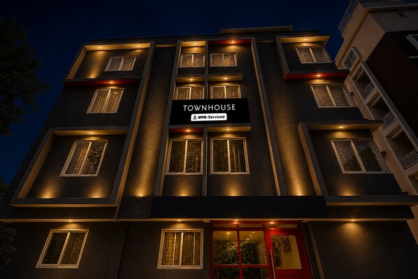 A multi-story building with a sign reading 'TOWNHOUSE' and 'Oyo-Serviced'.