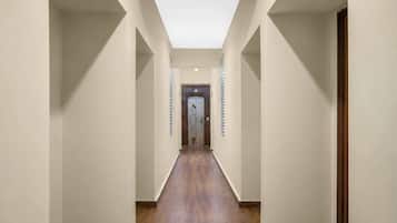A hallway with a skylight, wooden flooring, and a door at the end.
