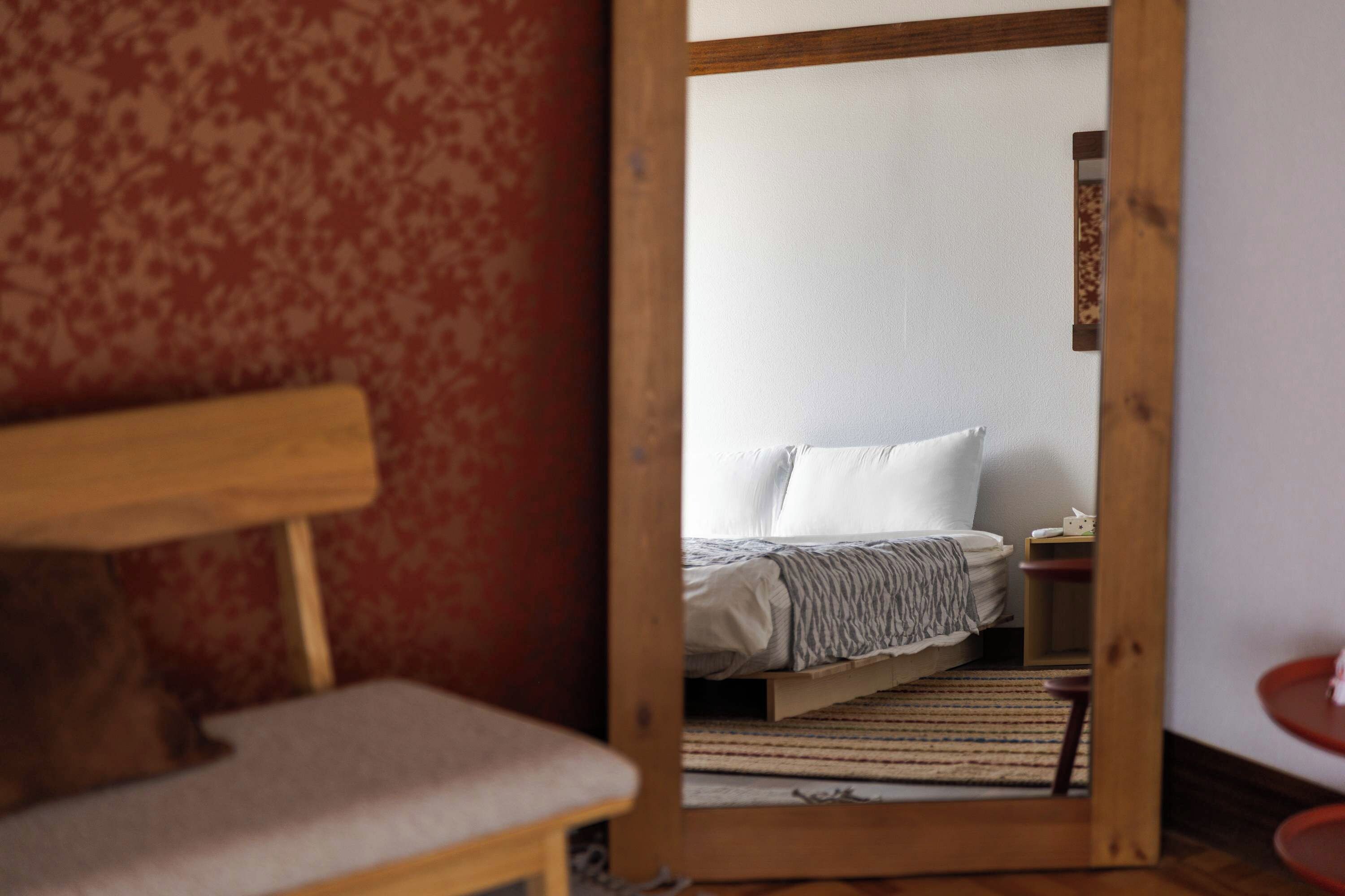 Une pièce comprenant un lit, un banc en bois et une petite table.