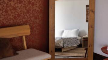 Une pièce comprenant un lit, un banc en bois et une petite table.