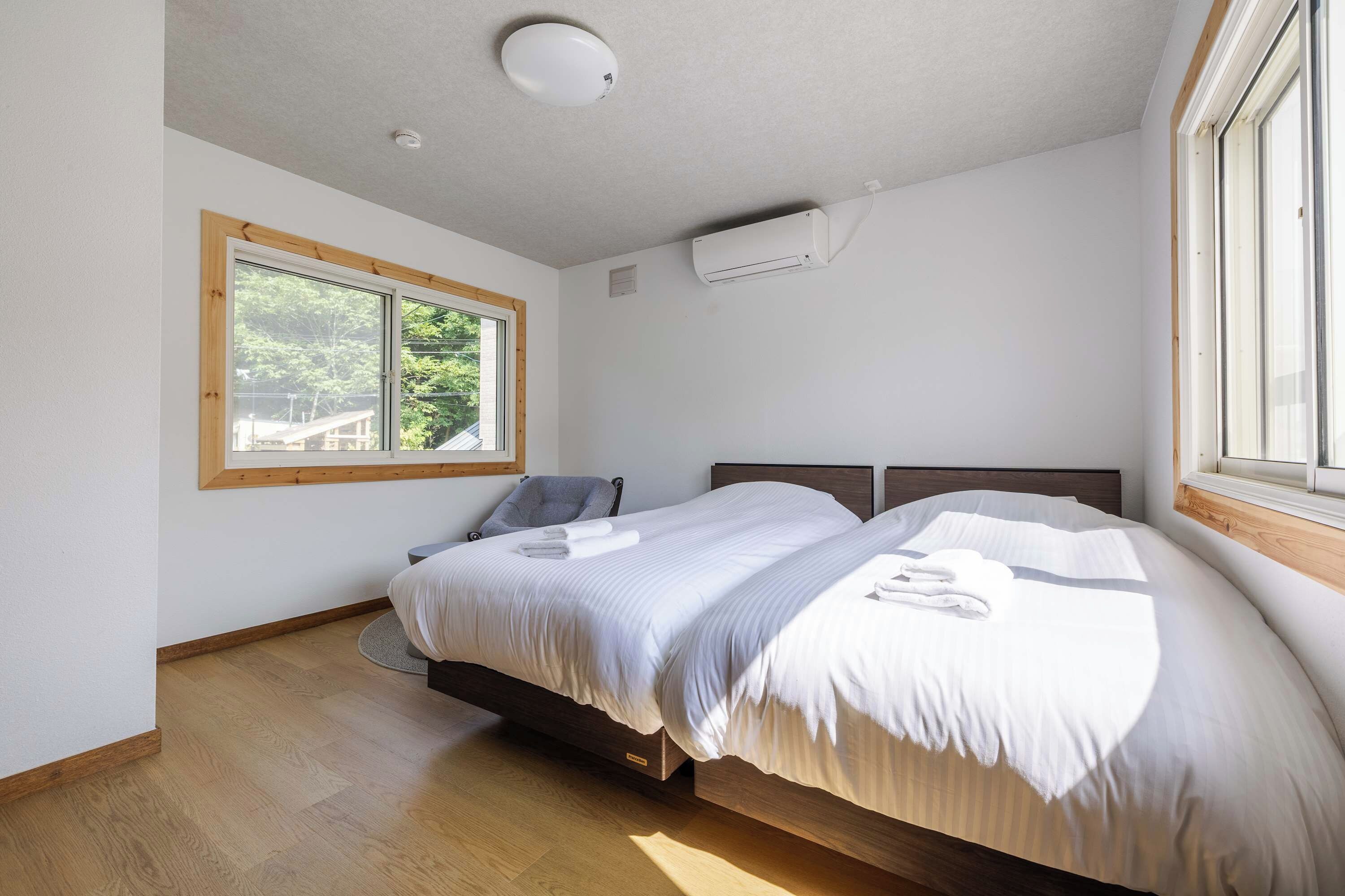 Een slaapkamer met een bed, een raam en een airconditioning.