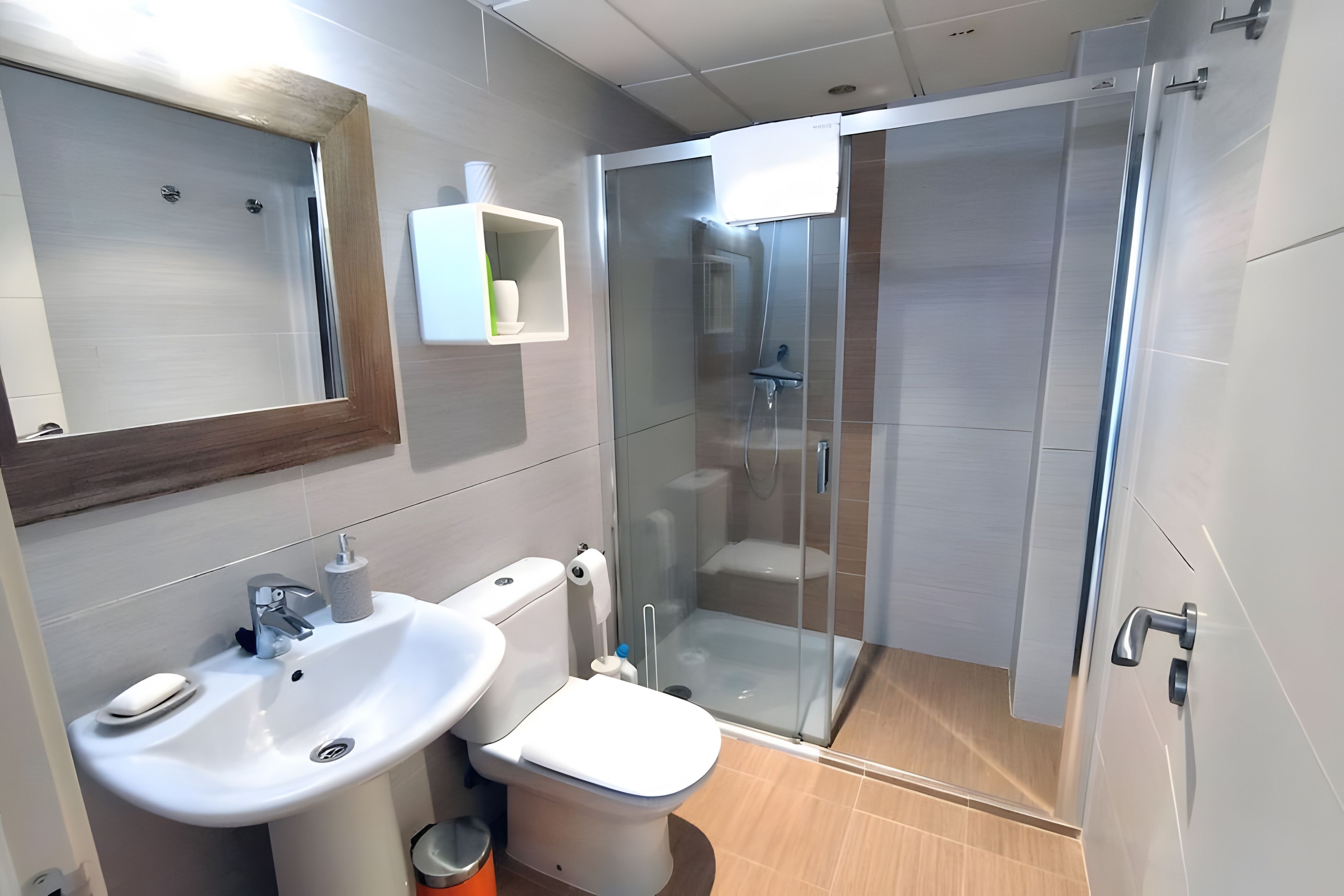 Une salle de bain moderne avec une douche à parois de verre, un lavabo et des toilettes.