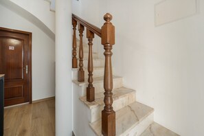 Una escala de fusta amb graons de marbre i barana.