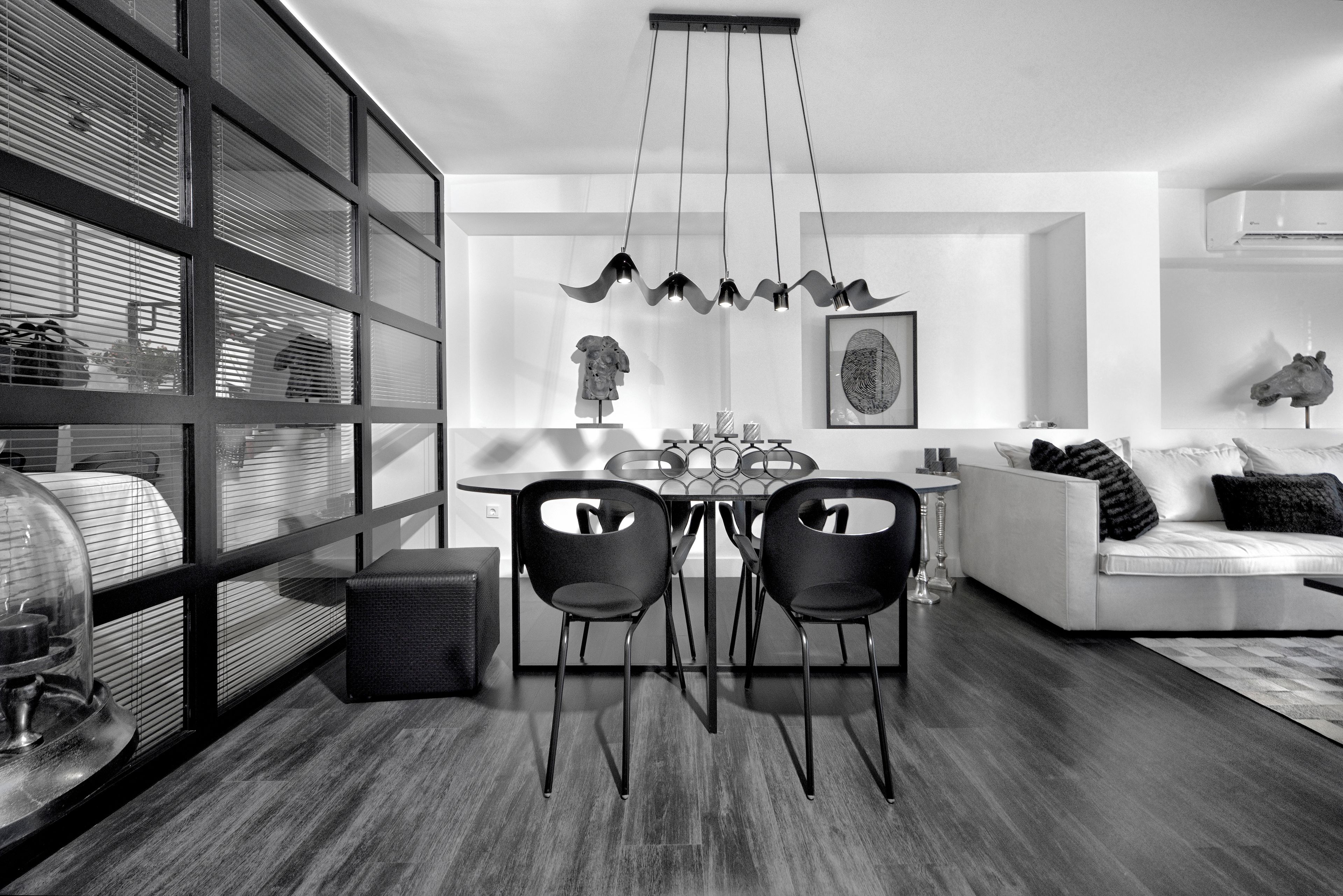 Un espace repas moderne avec une cloison en verre, une table ronde et deux chaises.