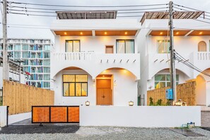 A modern two-story building with a flat roof, large windows, and a wooden door. - Villa C | 6BR Private Pool | Central Pattaya (Pattaya City)