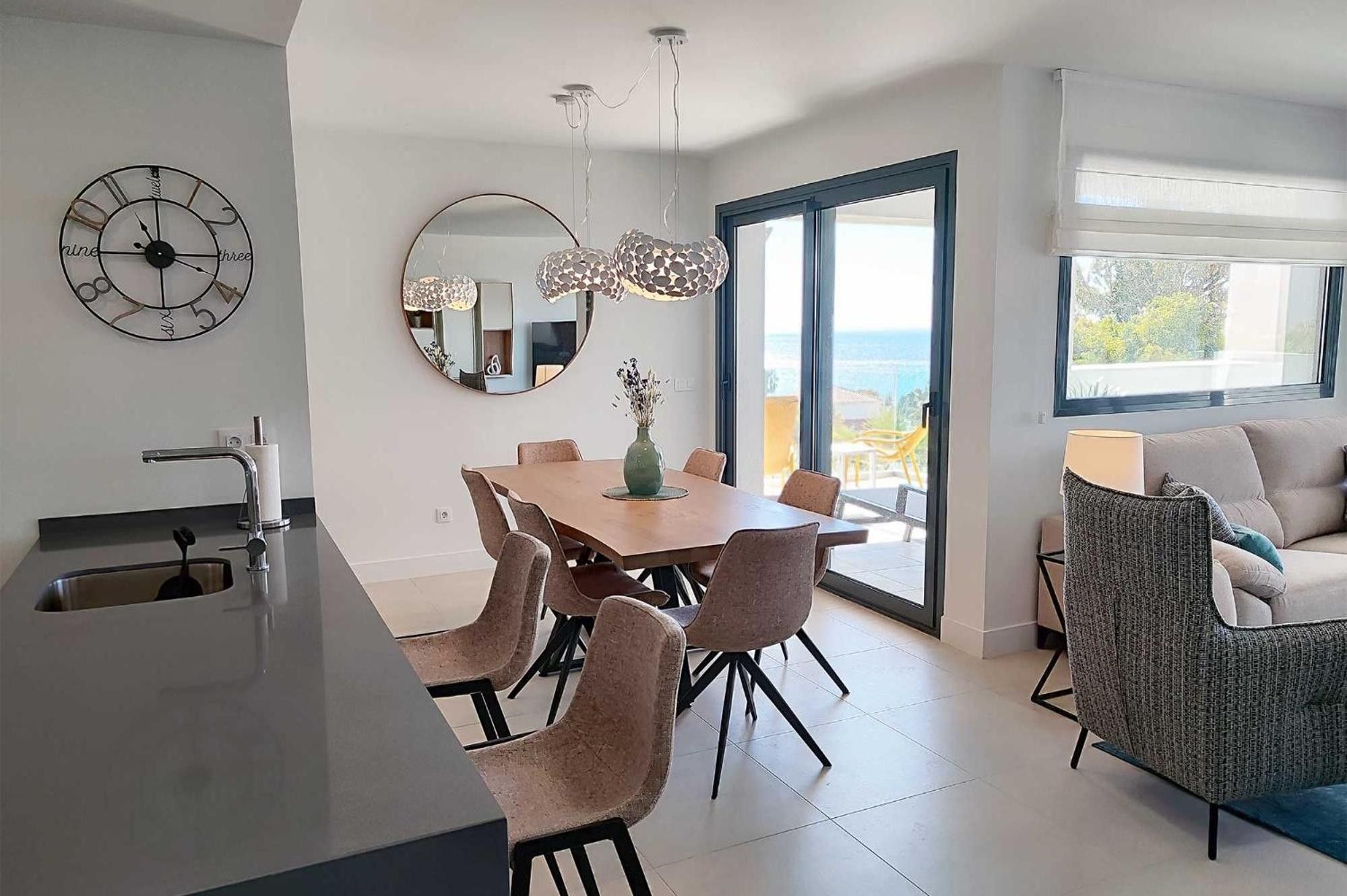 Una cocina moderna con comedor, un espejo grande y vistas al exterior.
