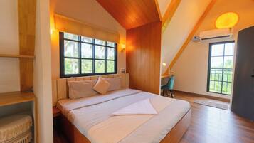 Un dormitorio con una cama grande, vigas de madera en el techo, un ventanal con vista a palmeras y un equipo de aire acondicionado.