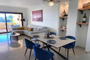 Een moderne woonkamer met een eethoek, een bank, een salontafel en een eettafel met stoelen.