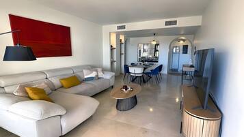 Un salon moderne avec un canapé, une table basse et un téléviseur.