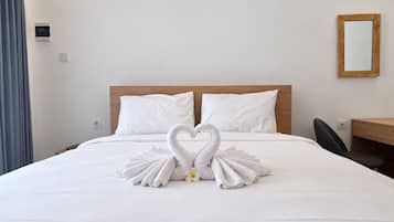 Ein Hotelzimmer mit einem Bett, einem hölzernen Kopfteil, einem Schreibtisch und einem Spiegel.
