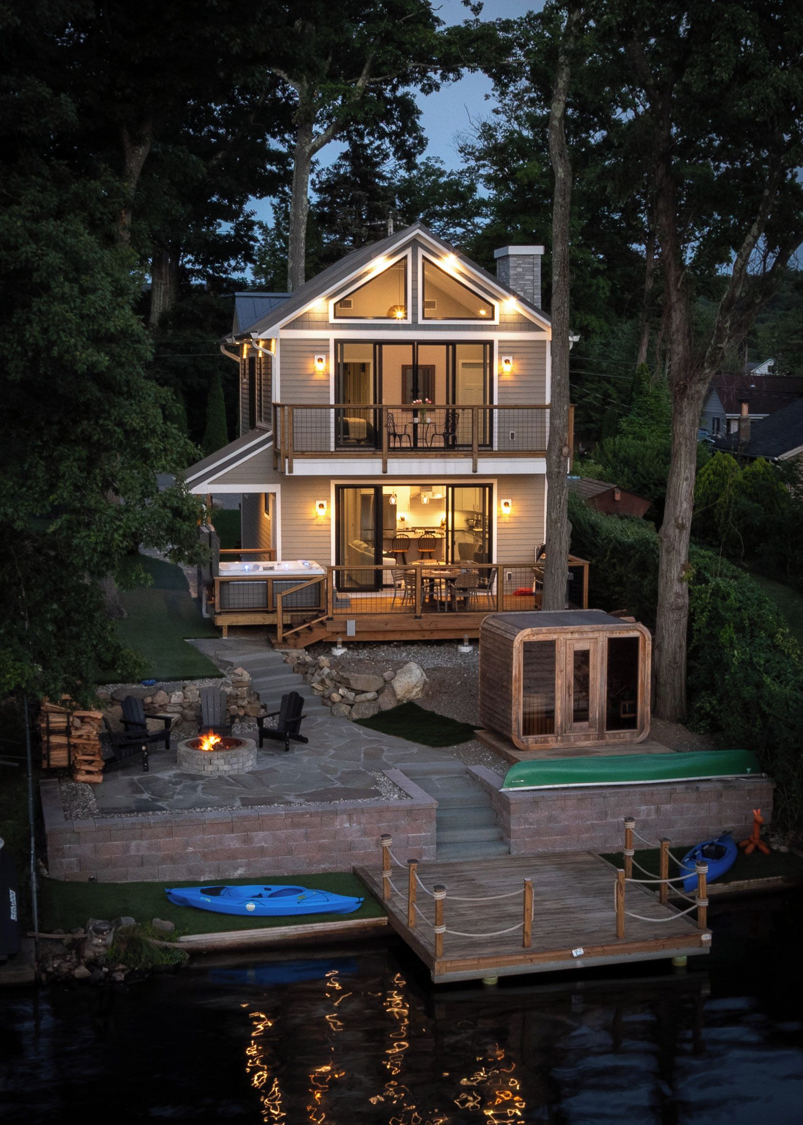 A two-story house with a deck and a hot tub.