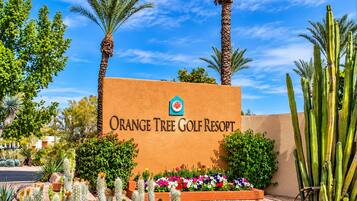The entrance sign of Orange Tree Golf Resort with a clear sky.