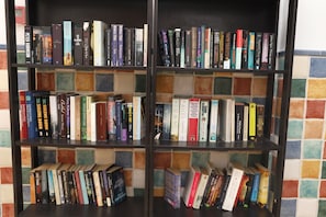 Una estanteria amb una varietat de llibres, alguns amb títols i autors visibles.