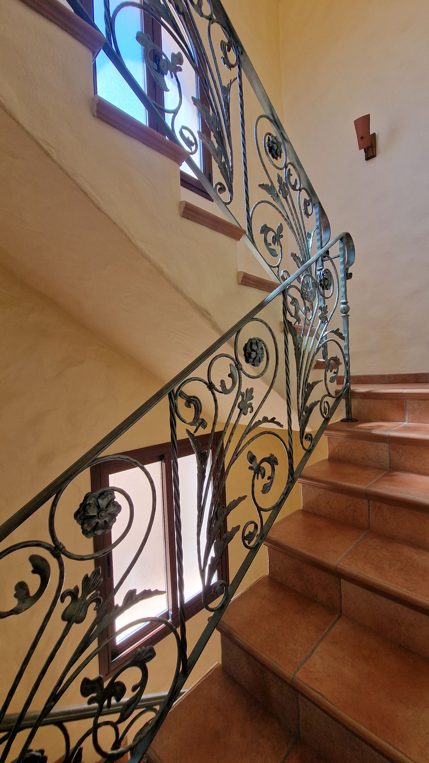 A staircase with ornate metal railings and wooden steps.