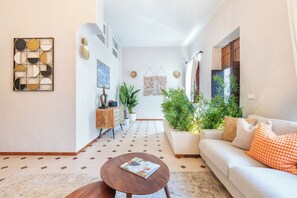 A modern living room with a sofa, coffee table, and decorative wall art. - Privilege St George House 5 Bedrooms & Hot Tub in the heart of Fuseta (Fuseta)
