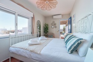 A bedroom with a bed, a window, a ceiling fan, and a wall-mounted air conditioner. - Privilege St George House 5 Bedrooms & Hot Tub in the heart of Fuseta (Fuseta)