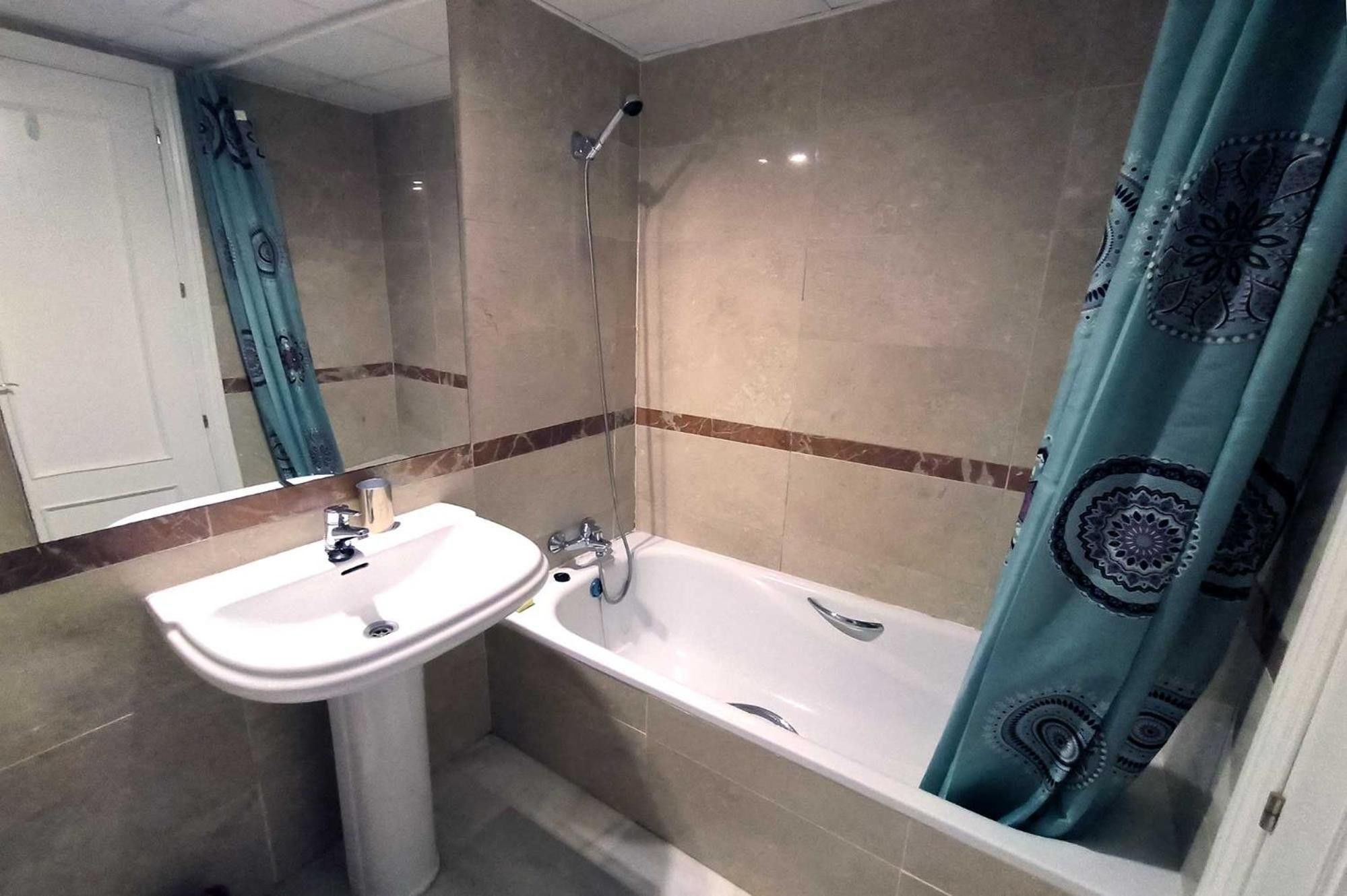 Un baño con lavamanos, bañera y ducha.