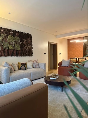 Ein modernes Wohnzimmer mit einer Couch, einem Couchtisch und einer Wanddekoration.