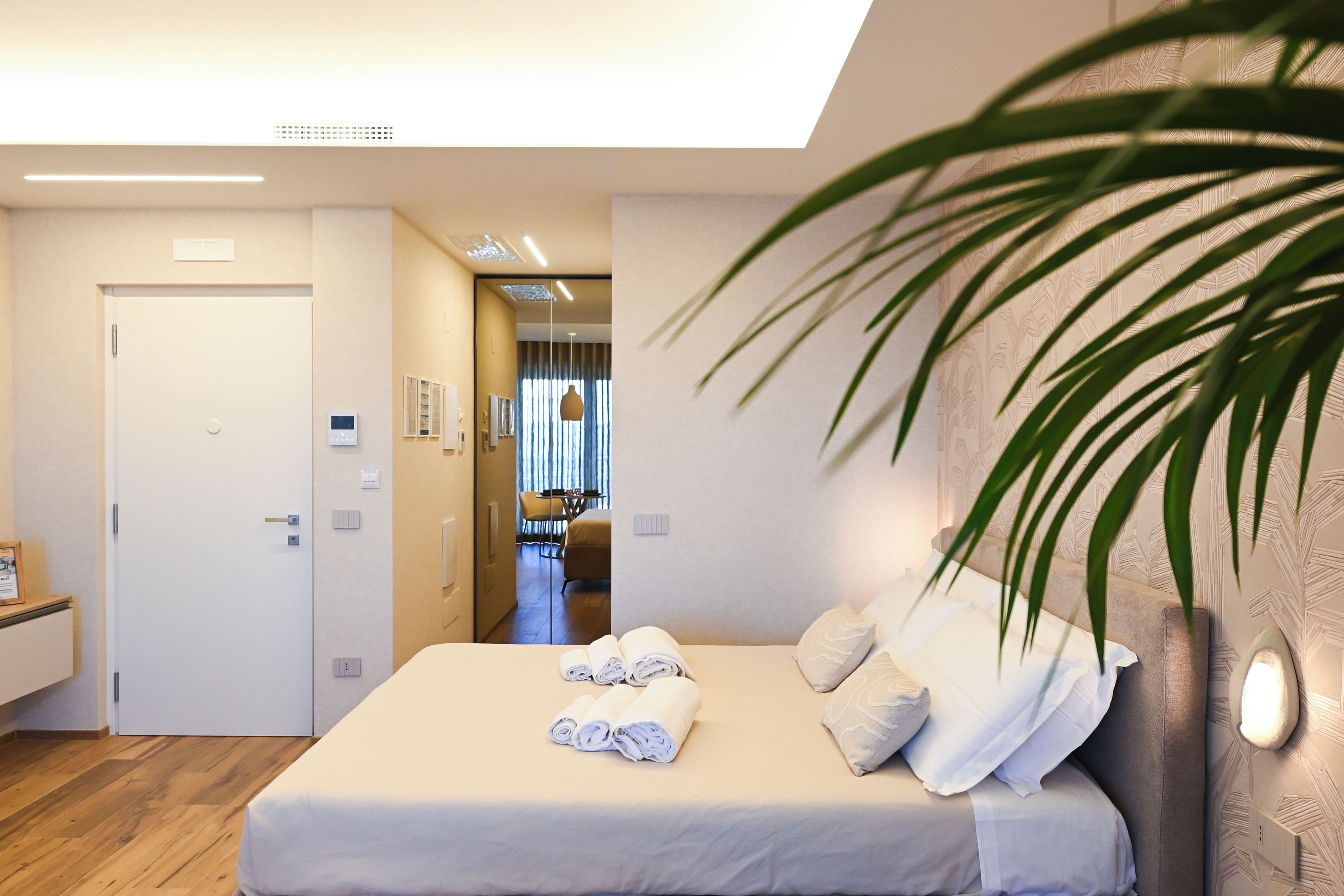 Een hotelkamer met een bed, een bureau, een stoel en uitzicht op de eetruimte.