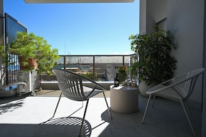 A balcony with two chairs, a round table, and potted plants. - Vimini Horizon (Bari)