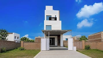 Un edificio moderno con techo plano, entrada cubierta y un letrero que indica que cuenta con servicios de OYO.