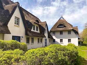 A traditional building with a steeply pitched roof, multiple windows, and a well-maintained garden. - Achtern Diek 12c - Apartment 3 (Zingst)