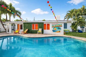 A poolside building with a sign reading 'Greetings from Florida' and 'The Sunshine State.' - Tropical Oasis: Private Pool & BBQ (Lighthouse Point)