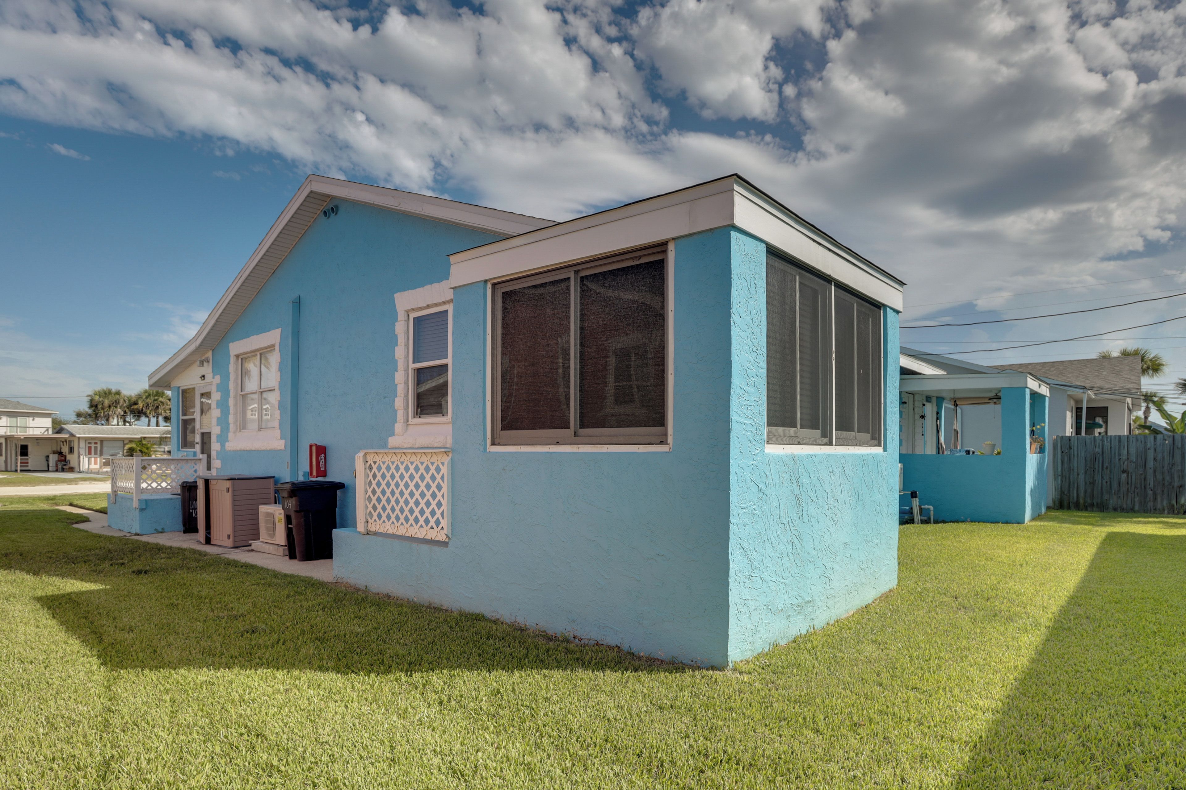 A single-story house with a blue exterior and a white trim around the windows and roof.