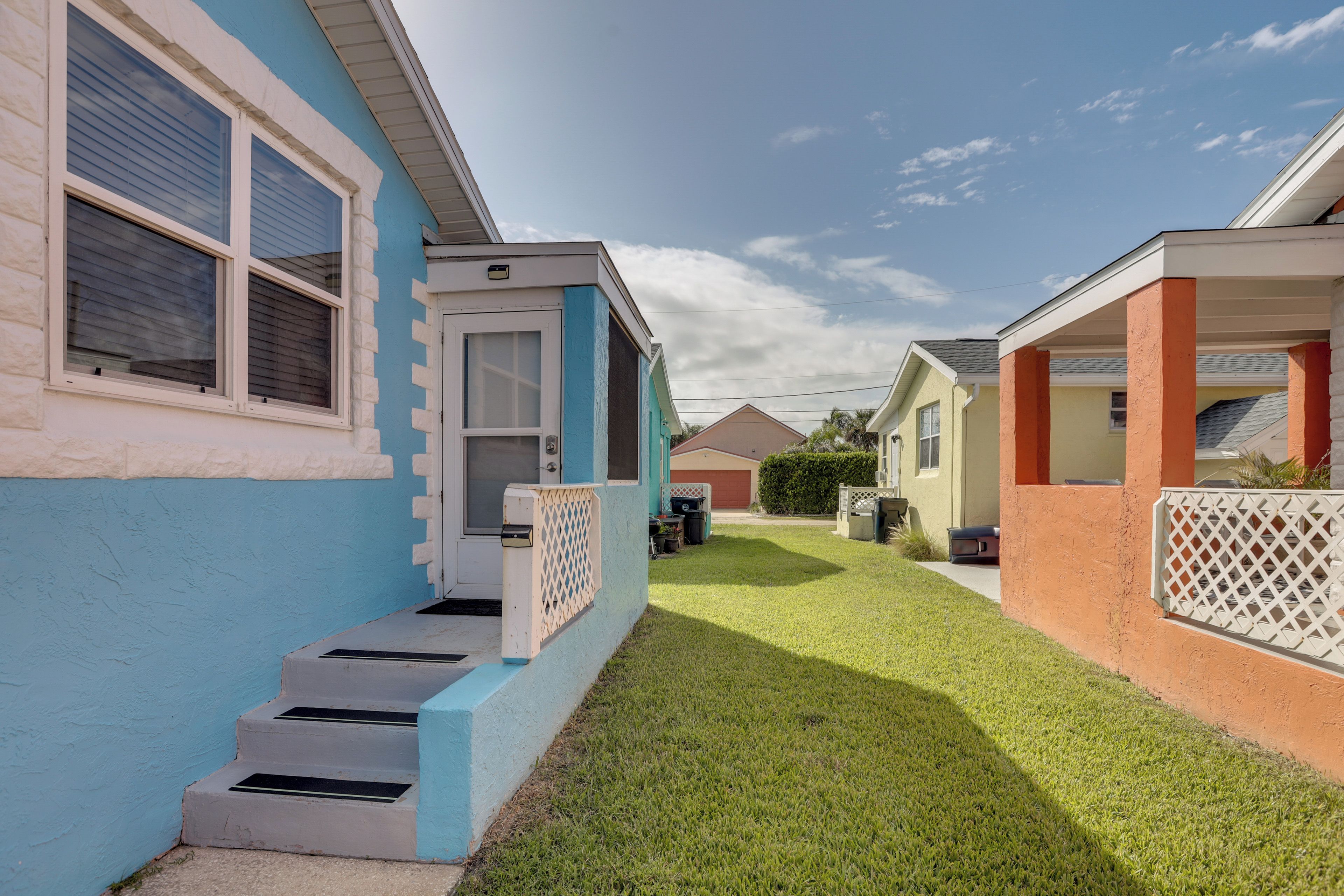 A row of single-story houses with a well-maintained lawn and a clear sky.