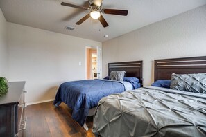 A bedroom with two beds, a ceiling fan, and a door leading to another room. - 7 Mi to Seaworld! Group-friendly Getaway w/ Pool (San Antonio)