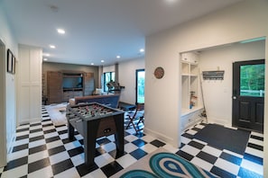 A room with a foosball table, a dartboard, and a television. - A Long Way From Durrow (Sautee Nacoochee)