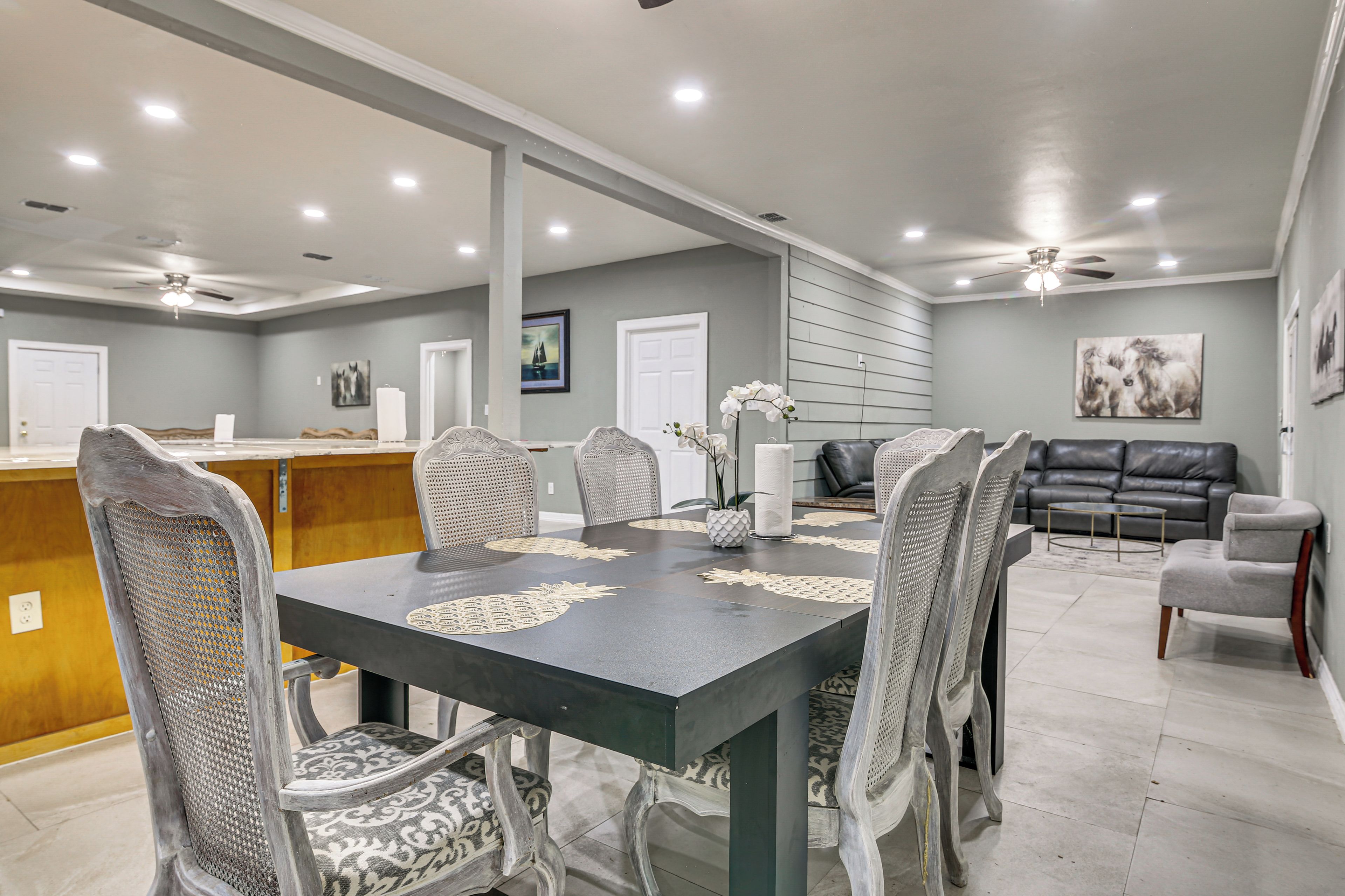 A dining area with a table, chairs, and a kitchen in the background.