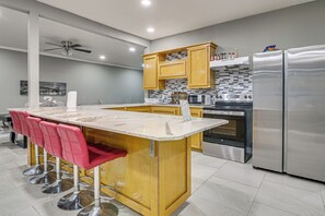 A modern kitchen with a central island, stainless steel appliances, and wooden cabinets.