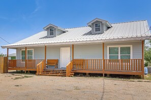 A single-story building with a porch, a front door, and a small staircase leading to the entrance.
