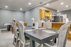 A dining area with a table set for four, surrounded by chairs with patterned upholstery.